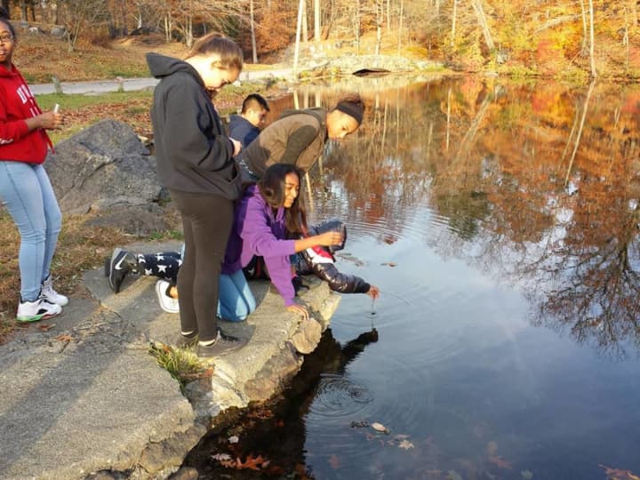 The Peekskill Middle School Environmental Club takes sample of water from Lake Mitchell.