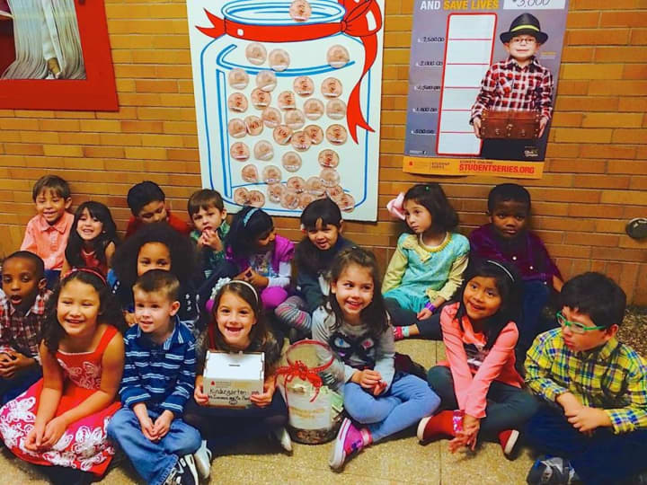 Students at Barnard Early Childhood Center assemble by a poster with paper pennies on it that represent their donations to the leukemia charity.