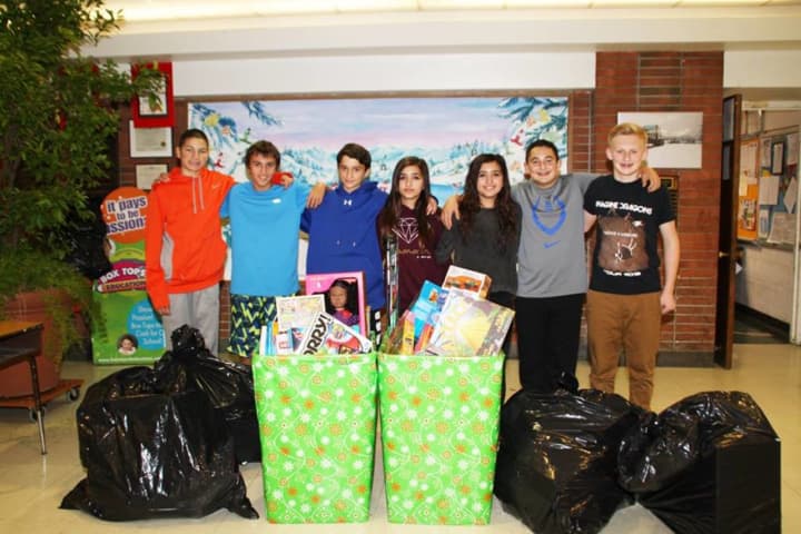 Pleasantville Middle School student council members pose with the proceeds from the toy drive they organized for the Fraternity of Notre Dame, which works with needy children in Harlem. 
