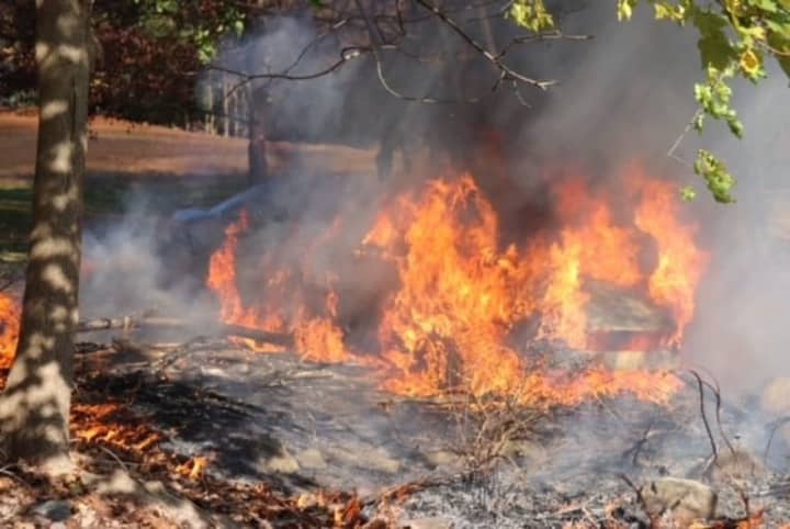 A firefighter pulled an unconscious person from a burning vehicle at a cemetery.