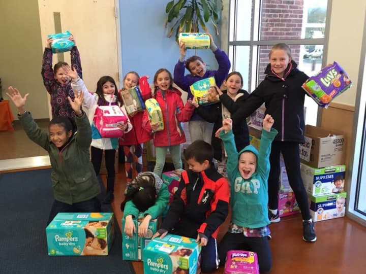 Children at the Village School Monessori hold up diapers their school collected for a CAFS diaper drive in May.