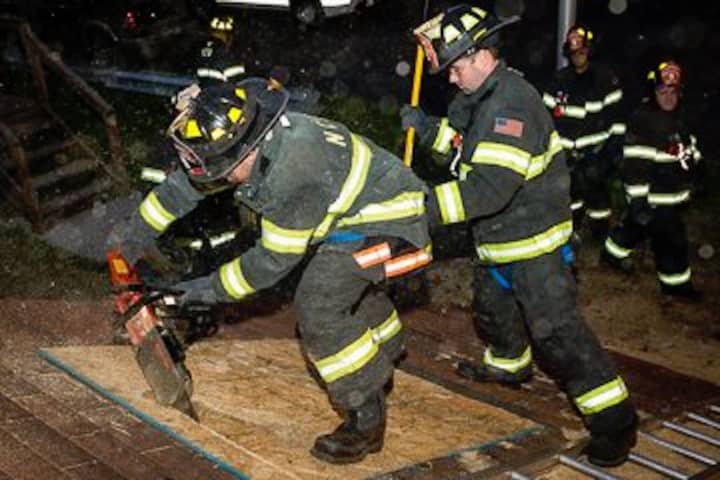 The New City Fire Department firefighters use power saw during the drill.