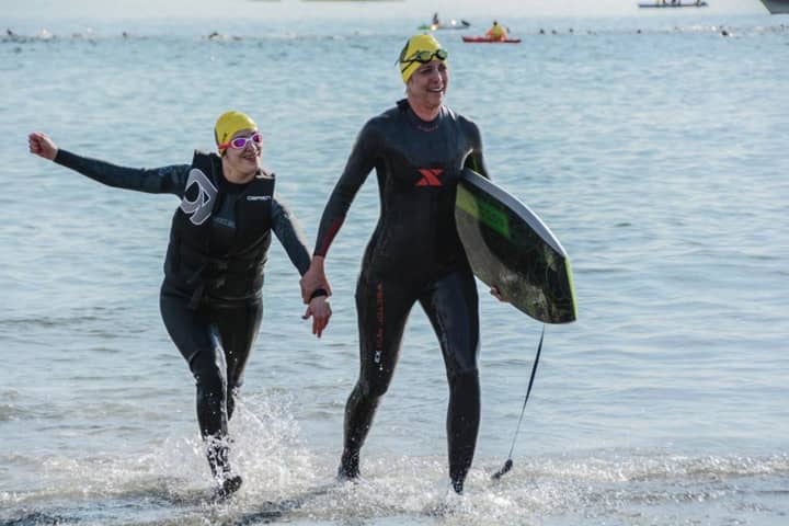 Chrissy Vita, left, and Terri Peri of Mahwah exit the water at the Cohasset Triathlon on Sunday.