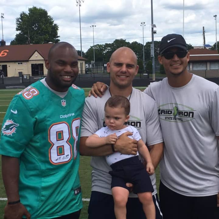 Wallington&#x27;s Adam Baeira, center, holds his son with Rutgers QB Gary Nova and Leonte Carroo of the Miami Dolphins.