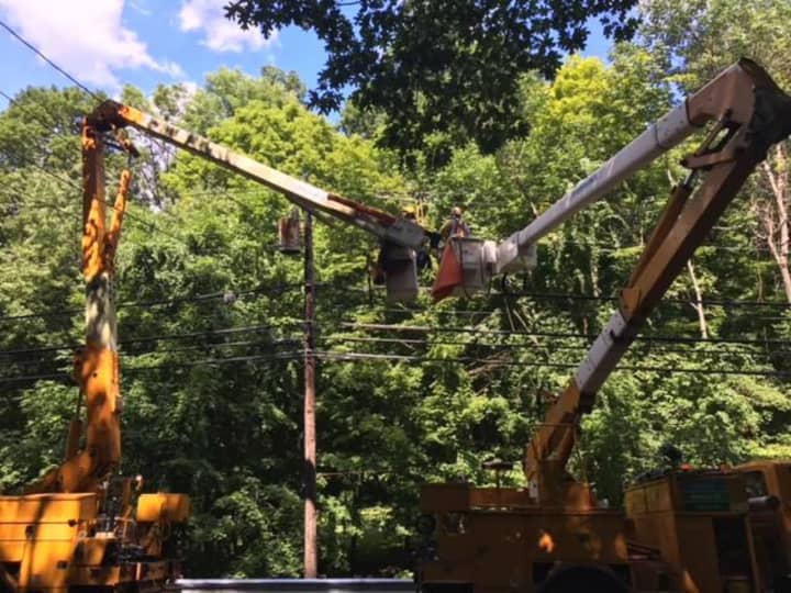 Eversource crews work to reroute power on Newtown Turnpike in Weston after a tree fell on the wires.