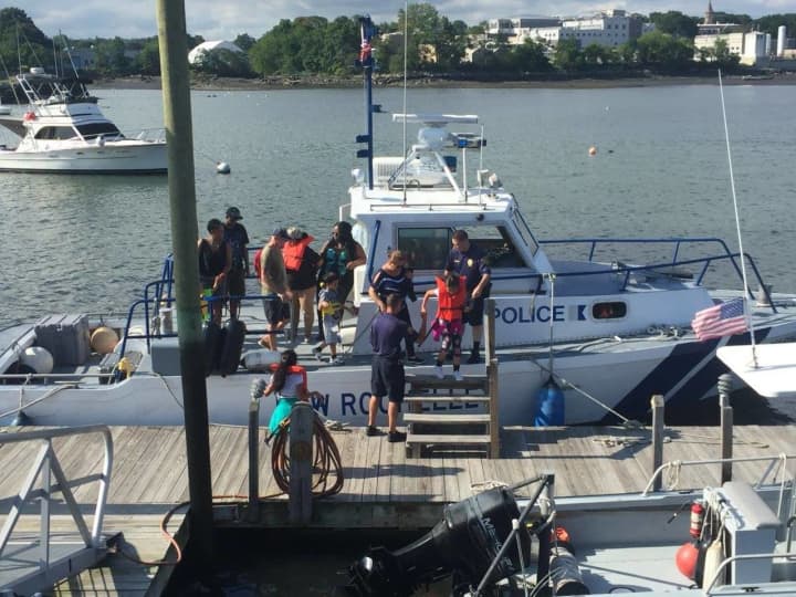A member of the New Rochelle Police Department Harbor Unit helped rescue two people stranded in the water after their boat hit a rock.