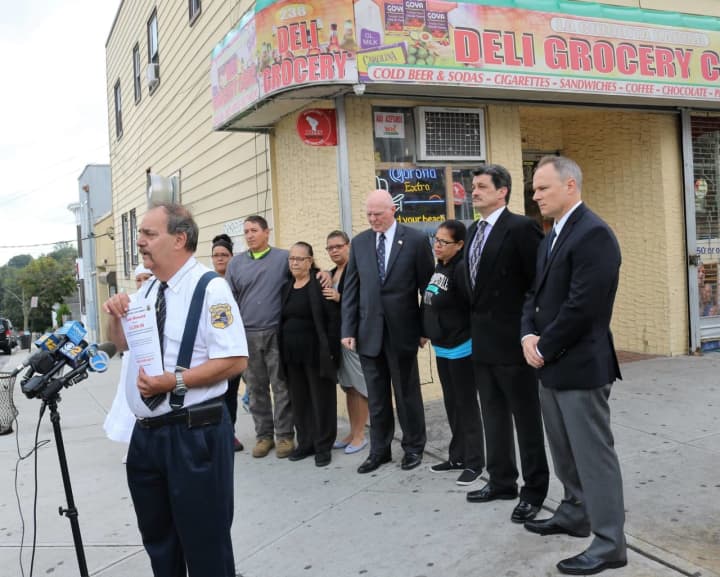 Members of the New Rochelle Police Department with Manuel Ayala&#x27;s family outside of the bodega he was shot at last month.