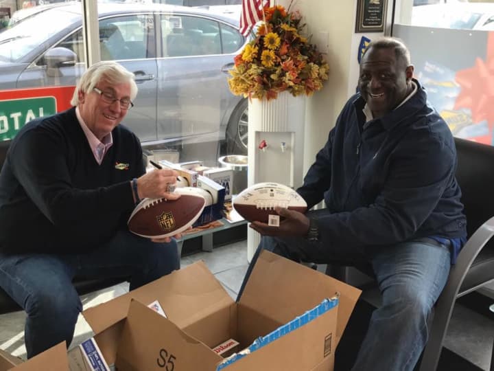 New York Giants great, Leonard Marshall and Mahwah Mayor Bill Laforet get together to sign footballs for kids with special needs.