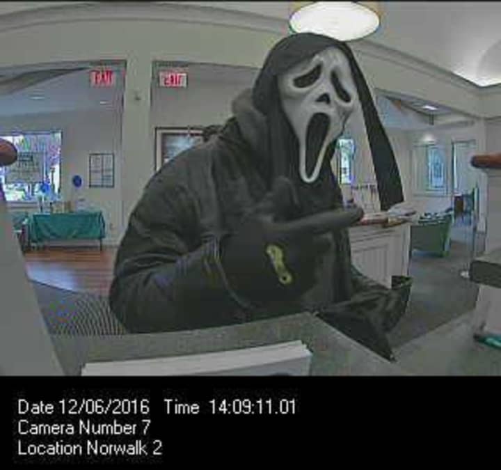 The suspect who robbed the First County Bank in Norwalk was wearing a ghost mask, a black leather jacket, and a black-hooded sweatshirt.
