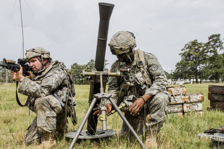 Spc. Hakeem English, a soldier assigned to Headquarters Co., 2nd Battalion, 108th Infantry, sets up a 60mm mortar while Spc. Elliot Beaumont provides security at Fort Polk, La.,