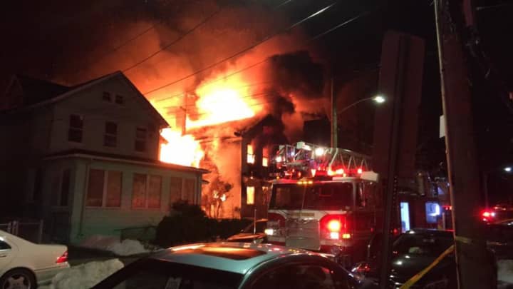 Firefighters battled a two-alarm blaze that destroyed a Mount Vernon home and spread to other buildings overnight.