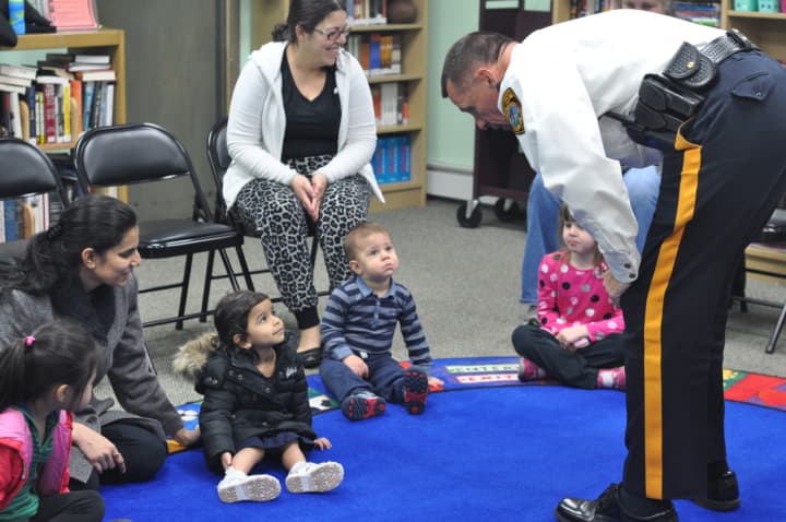 East Rutherford Police Chief Larry Minda reads to children at the library.