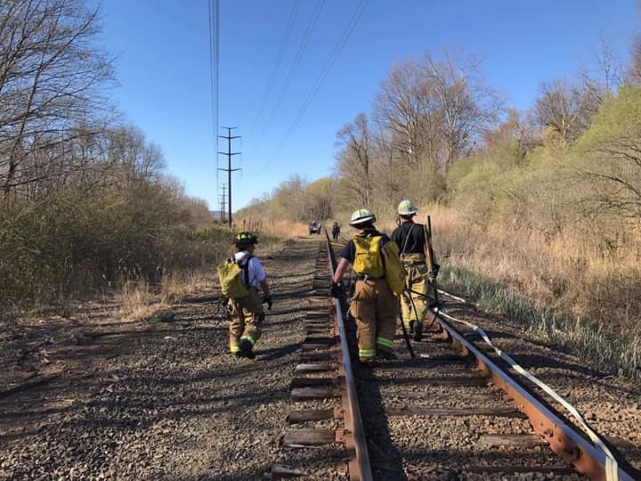 The brush fire is reported along the train tracks in Brookfield on Tuesday.