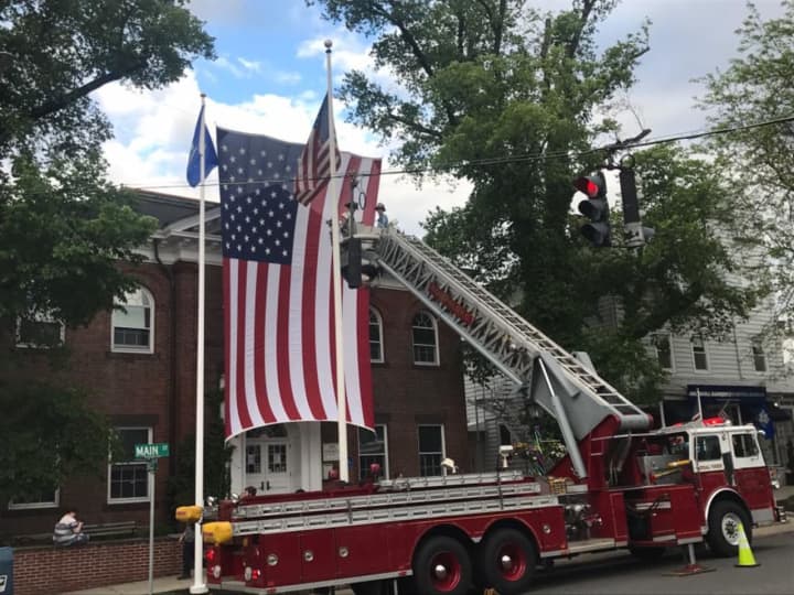 The Ridgefield Volunteer Fire Department hangs the flag at Town Hall for Memorial Day.