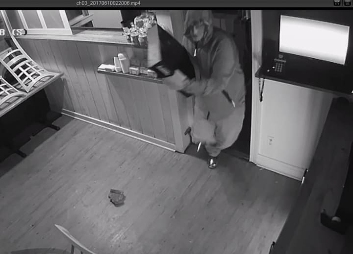 The suspect in the burglary of Rowayton Pizza grabs the cash register and flees.