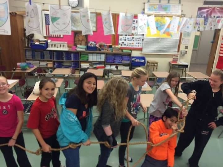 Wayne students participate in a group activity with a rope.