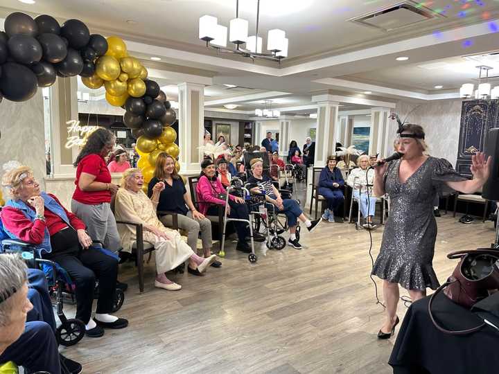 Singer Mary Taylor performs songs from the 1920s for Rosemarie, her daughter Michele, and the rest of the Harmony Village residents and staff.