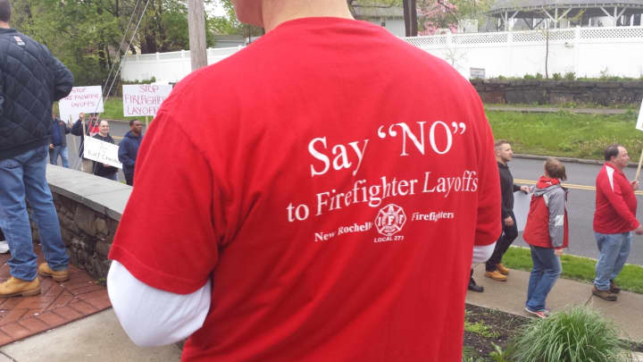 Dozens of protesters wore red shirts during a rally May 3 that said: &quot;Say &#x27;NO&#x27; to Firefighter Layoffs.&quot; The Village of Rye Brook filed a lawsuit against the Village of Port Chester on Tuesday claiming a breach of contract for firefighter services.
