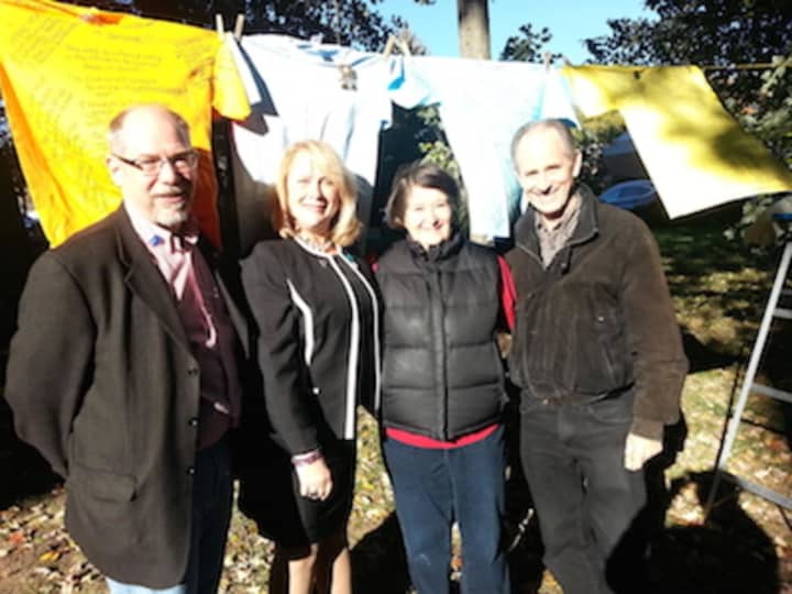 Trumbull Rotary Club President Ed Gillespie, Center for Family Justice President and CEO Debra A. Greenwood and Rotarians Sue Horton and Steve Hodson stand in front of The Clothesline Project in Trumbull.