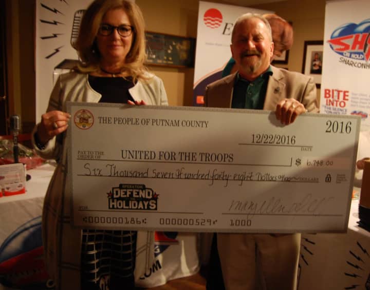 Putnam County Executive MaryEllen Odell presents United For The Troops co-founder Jim Rathschmidt a check from the donations collected through the Defend the Holidays campaign.