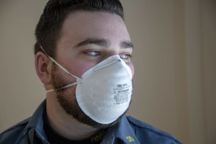 Holy Name Medical Center security guard Brendan McLaughlin dons his face mask.