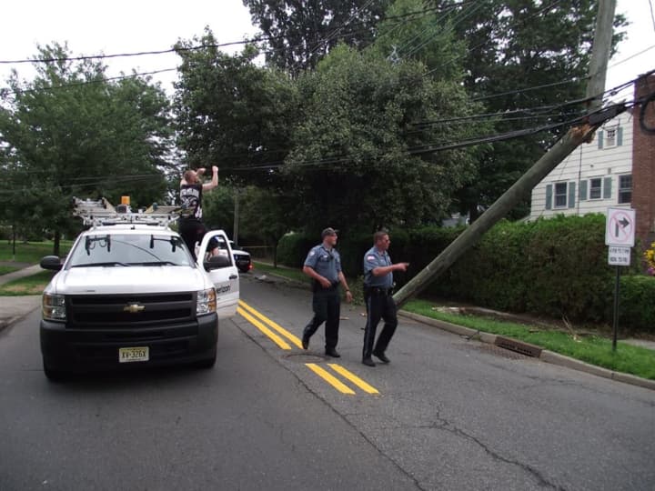 Ridgewood police assess the damage done to a utility pole after an SUV crashed into it on Tuesday.