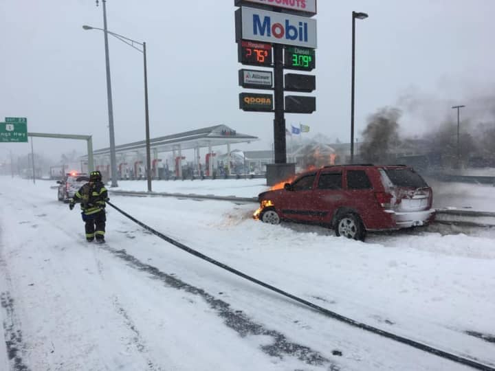 Fairfield firefighters douse a burning car on I-95 northbound near the rest area during Thursday&#x27;s nor&#x27;easter.