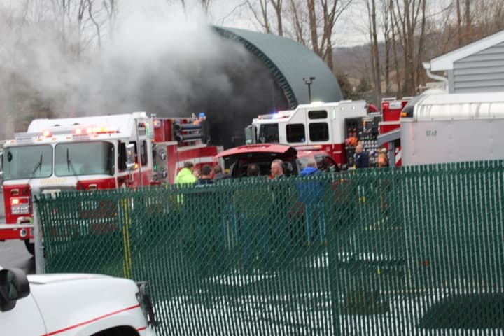 Smoke billows out of the enclosure that held a fully involved dumpster in Mahopac.