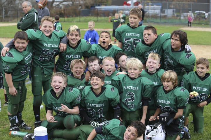 The third- and fourth-grade White team players are all smiles after completing an undefeated season.