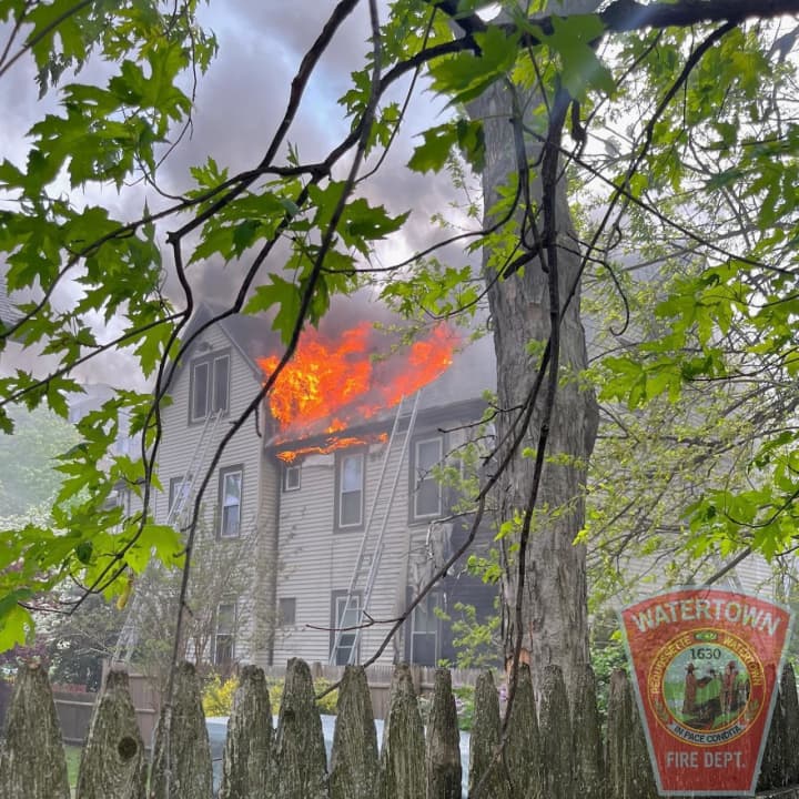 Flames shoot from a home on Maple Street in Watertown on Thursday afternoon, May 11