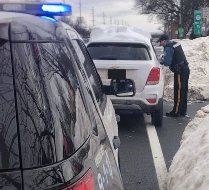 A Paramus police officer pulls over a motorist with rooftop snow Wednesday, Feb. 3, 2021.