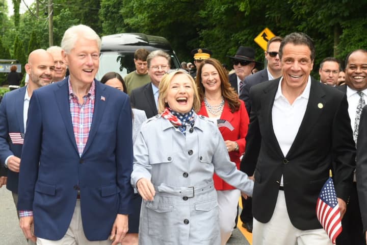 They love a parade: Gov. Andrew Cuomo marches alongside Bill and Hillary Clinton in the New Castle Memorial Day Parade.