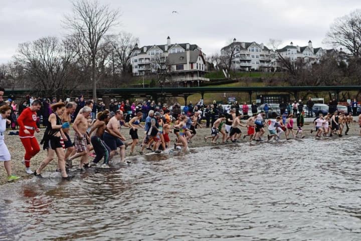 People run into the frigid water as part of the annual polar plunge in Peekskill