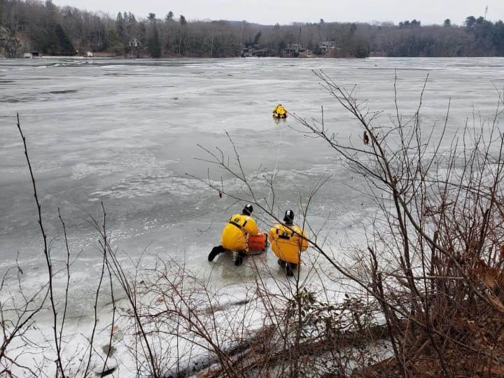 Members of the Stevenson Volunteer Fire Department work to save a deer trapped on ice.