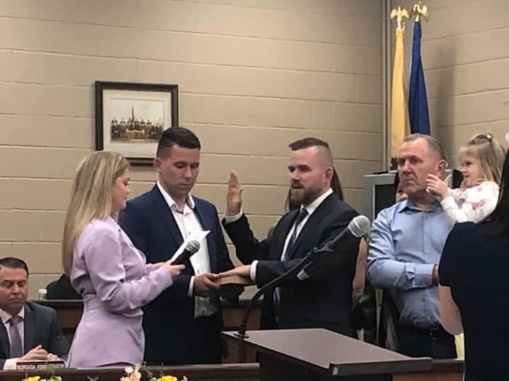 Daniel Golabek being sworn in by borough clerk Erin Delaney. His brother and school board member, Jakub, holds the bible.