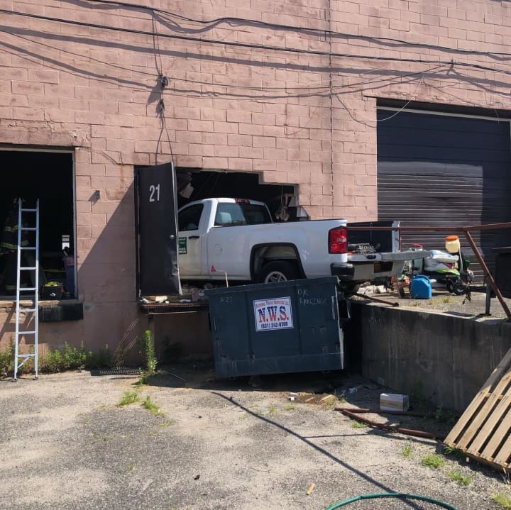 A driver suffering a medical emergency slammed into a building, injuring two workers inside.