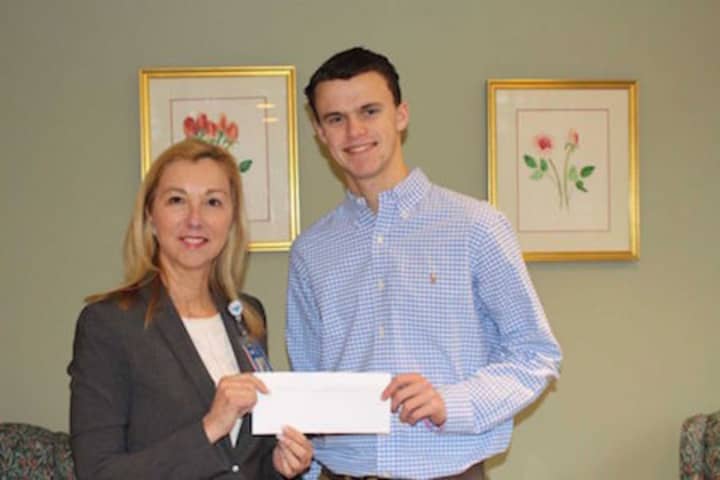 Mason Jennings, a senior at Fairfield Ludlowe High School, presents Dr. Donna Twist, executive director of the Norma Pfriem Breast Center at Bridgeport Hospital, with a $500 donation.