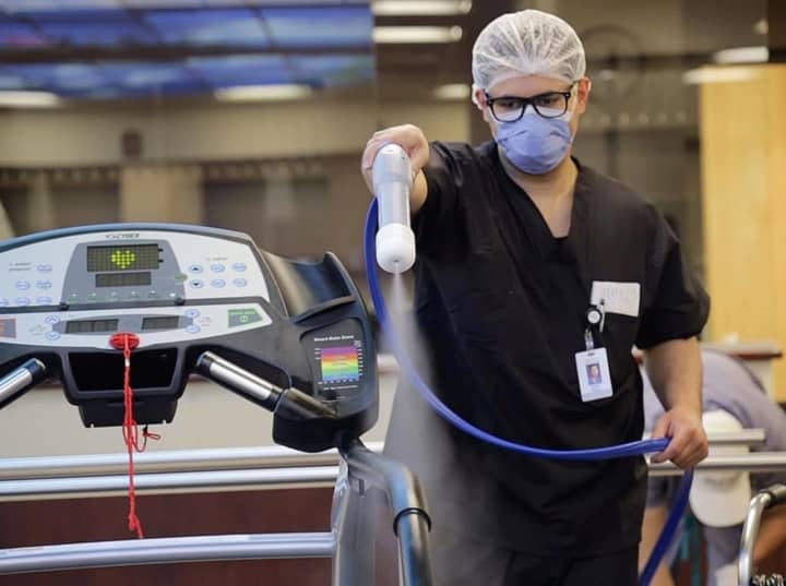 A Holy Name Health nurse sprays down a treadmill