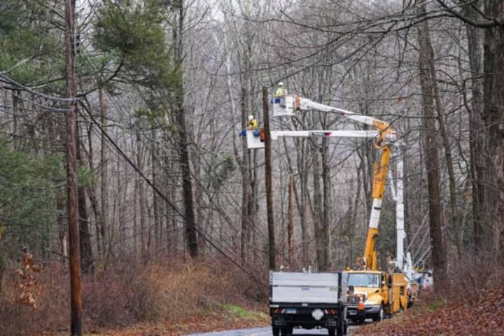 United Illuminating crew works to restore power near Clark Road. in Woodbridge, on Friday, Dec. 23, an outage that affected 1,200 customers after a tree fell on electrical wires.