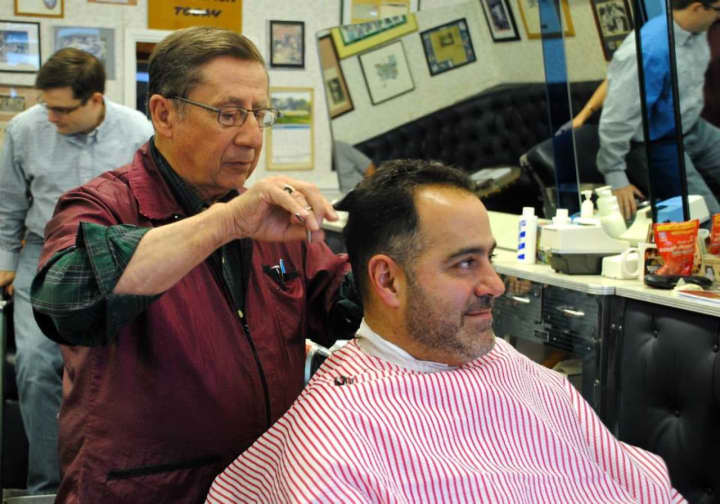 Joe Vaccarella cuts a customer&#x27;s hair Barber Serville in Fairfield in this 2013 photo. The shop is closing and Vaccarella who has been barbering for 61 years will retire.