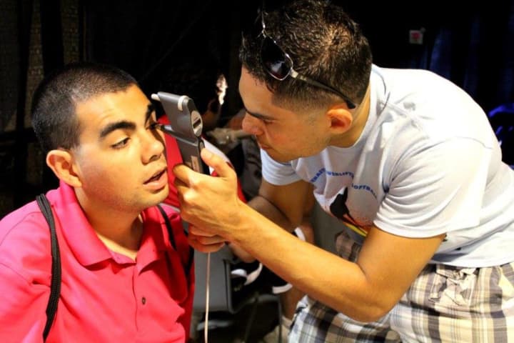 Vittorio Mena gives an eye exam to a patient during a humanitarian trip to Haiti in August of 2014.