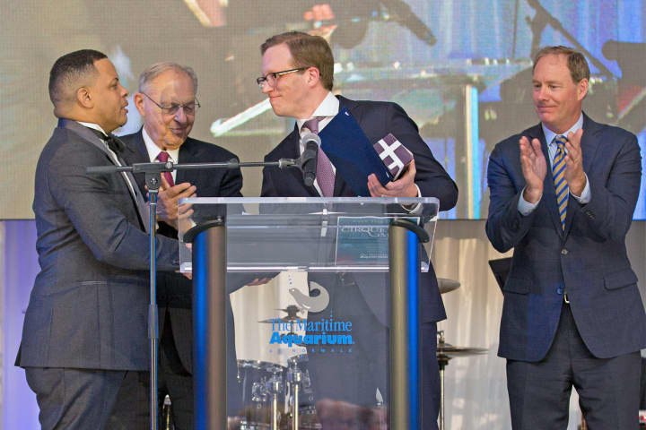 Elliott Bundy on New Canaan, a managing director of XL Catlin, accepts a Red Apple Award on behalf of the global insurer during The Maritime Aquarium at Norwalk’s “Cirque de la Mer” gala on April 20.