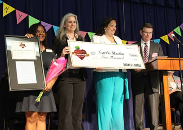 Carrie Martin, second from right, is presented with a check by Barnes &amp; Noble officials after being named National Teacher of the Year for 2015-2016. Martin teaches second grade at the Evers Park Elementary School in Denton, Texas,  .