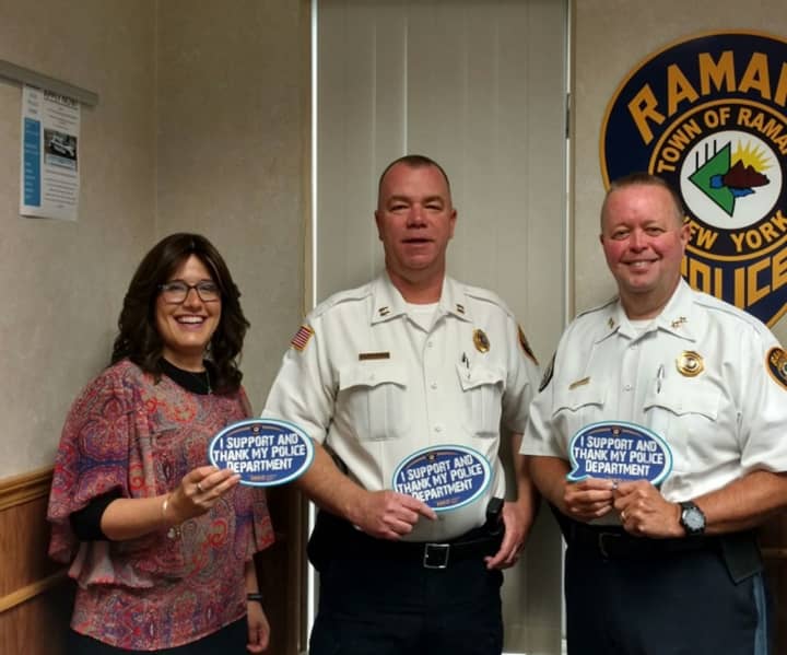 Monsey resident Shoshana Bernstein, left, holds one of the magnets she conceived to show appreciation for police. With her are Ramapo Police Chief Brad Wiedel, right; and Capt. Martin Reilly.