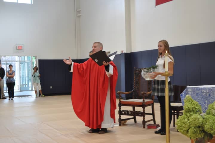 Father Matt Janeczko celebrated a Mass of the Holy Spirit on Monday at School of the Holy Child, blessing a new field house during a ceremony in The Kelly Gymnasium. Assisting him during the ceremony was Holy Child sophomore Annabelle Schultze.