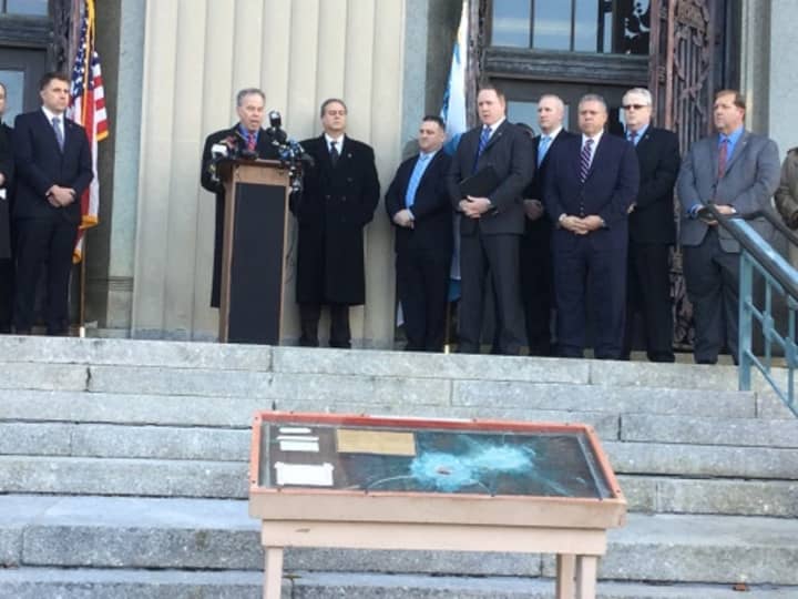 Rockland County Executive Ed Day, surrounded by law enforcement officials, reads a statement demanding that convicted Brink&#x27;s robber Judtih Clark stay in prison. The bullet-riddled windshield from the armored car is displayed on the courthouse steps.