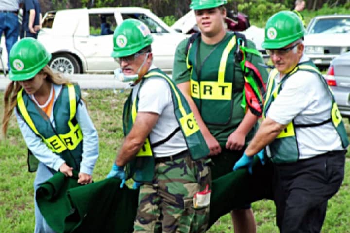 Ordinary citizens are encouraged to join the local emergency response team. These team members are carrying a disaster survivor.