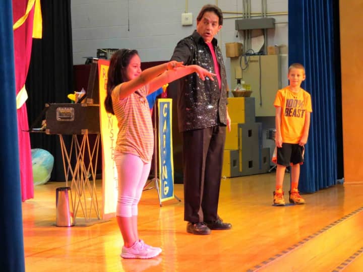 Carrie E. Tompkins Elementary School students Ingrid, left, and Max, aided James “Magic Jim” Vagias in performing magic tricks during his show that encouraged them to embrace the themes of respect, responsibility and caring.