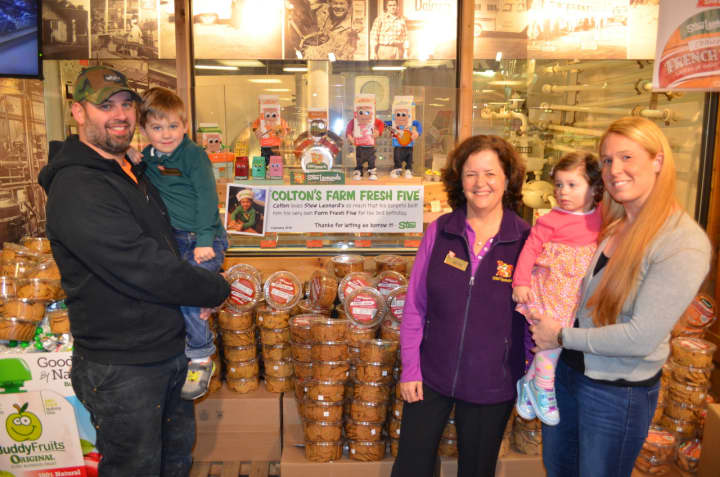 Shelton resident Peter Johnson (holding Colton), Beth Leonard Hollis and Lauren (holding Oakley) in front of their miniature version of the Farm Fresh 5