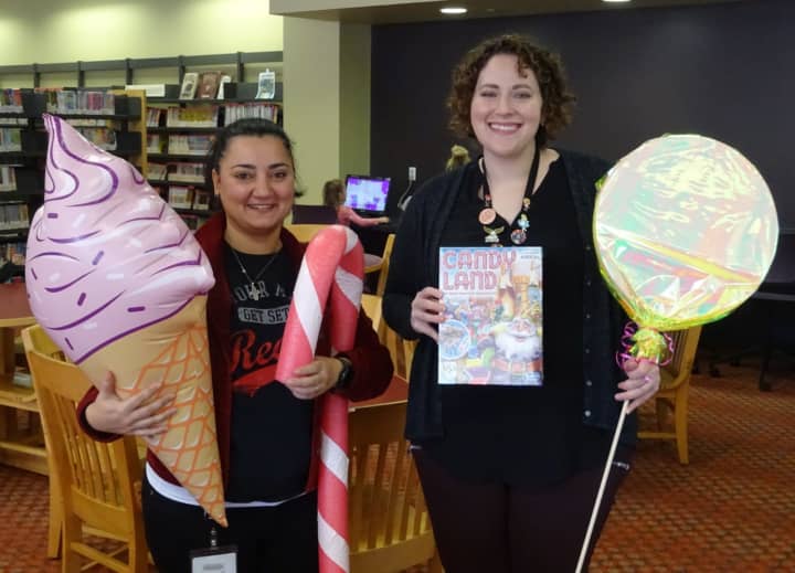 Rola Salloum and Caitlin Siciliano, who both work at the Mahwah Public Library, pose with some of the props that will be used for the life-sized Candy Land game.